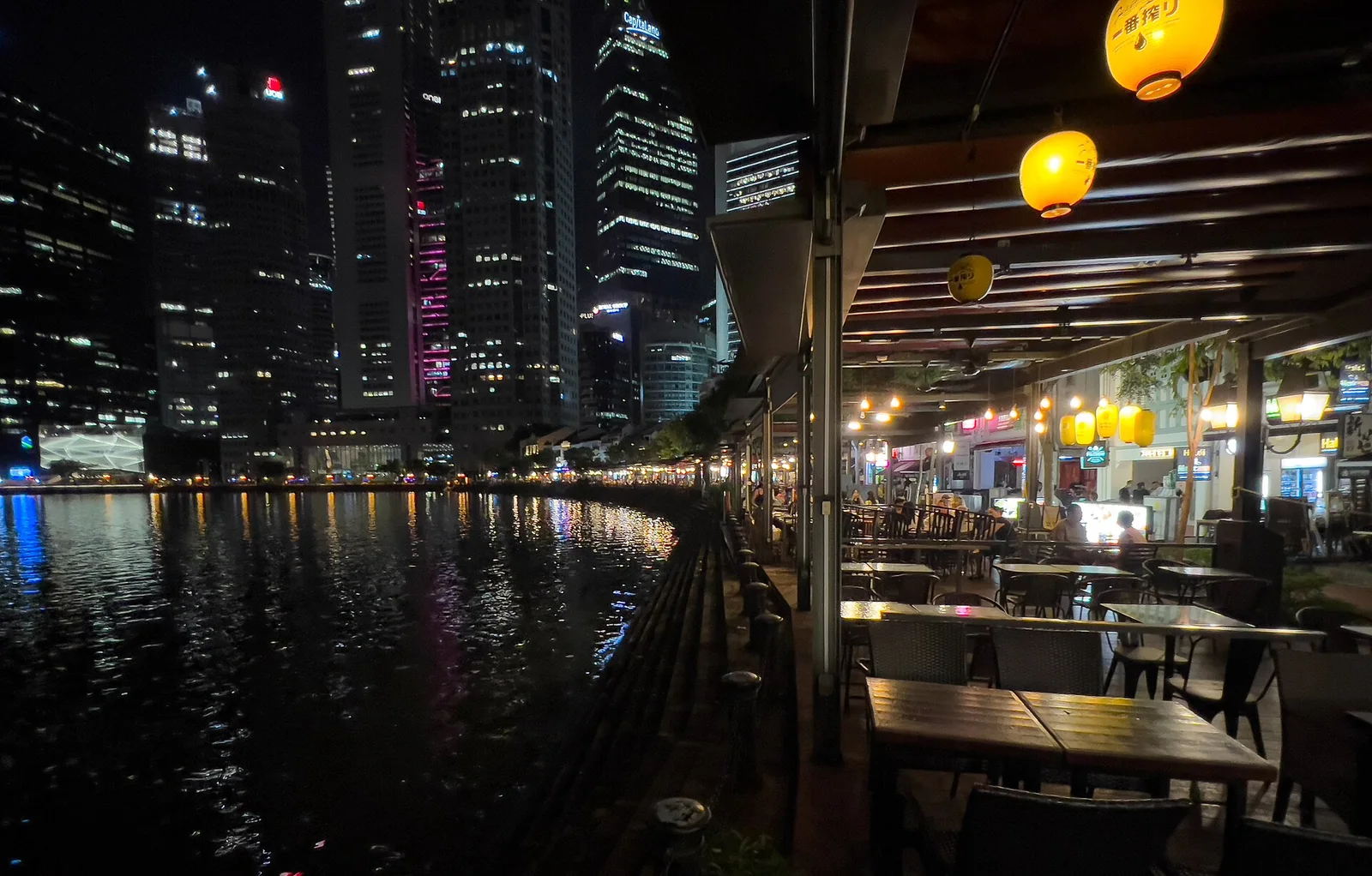 驳船码头沿河檐下的灯笼、空座位与对岸商务区夜景